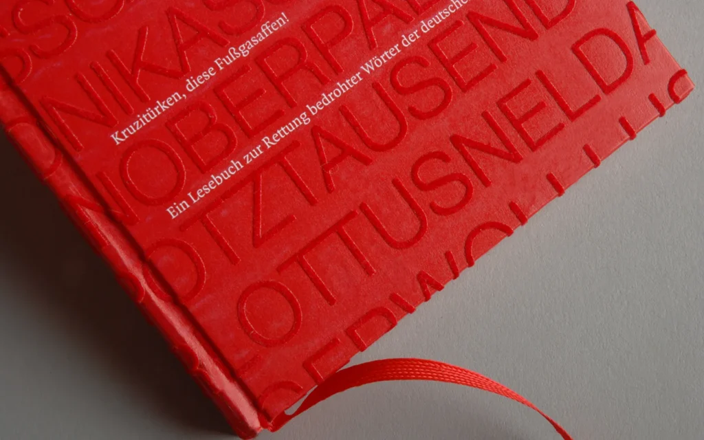 Rotes Buch mit kuscheligen Buchstaben im Flockdruck rot auf rot