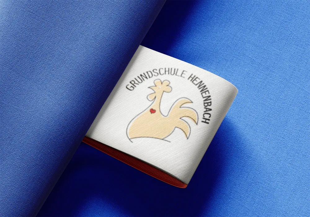 Logoentwicklung für die Grundschule Hennenbach - hier als Beispiel auf einem Textillabel